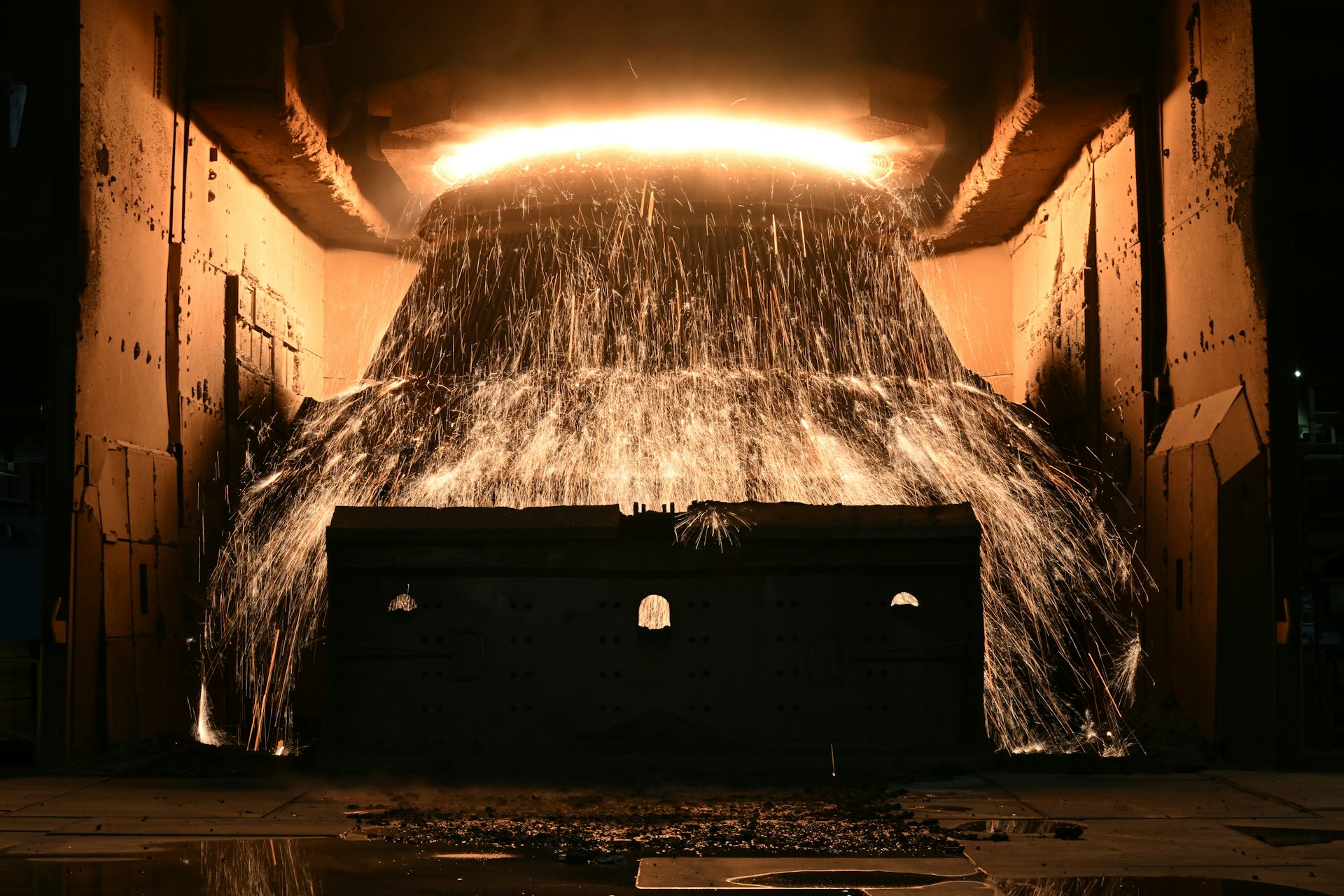 molten steel flowing from large container.
