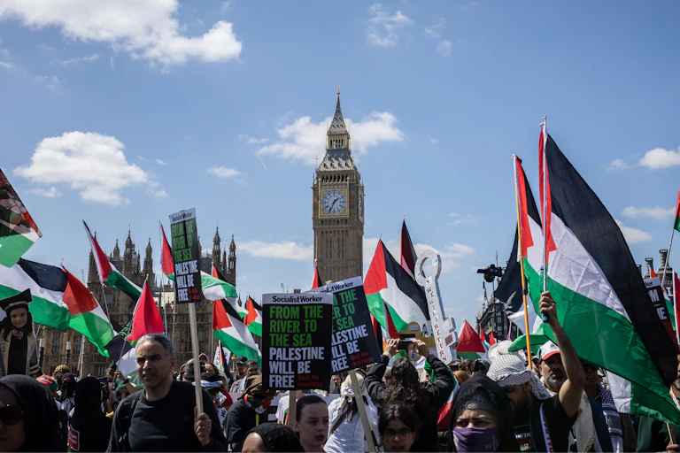 Marchers carrying Palestinian flags in London, with Big Ben visible in the background