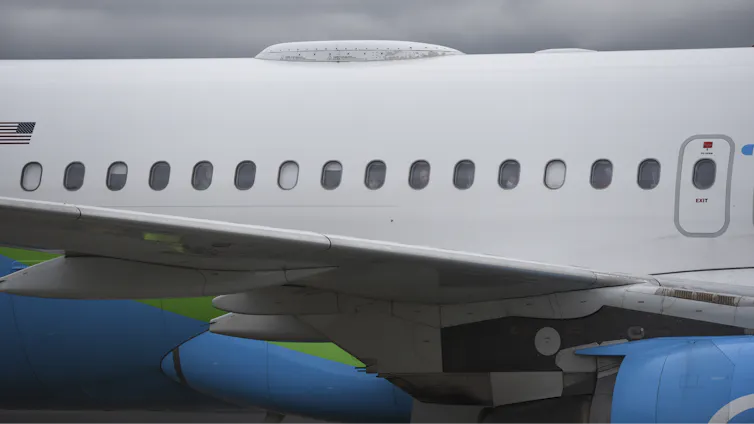 the body of a jetliner with the blinds down on some windows