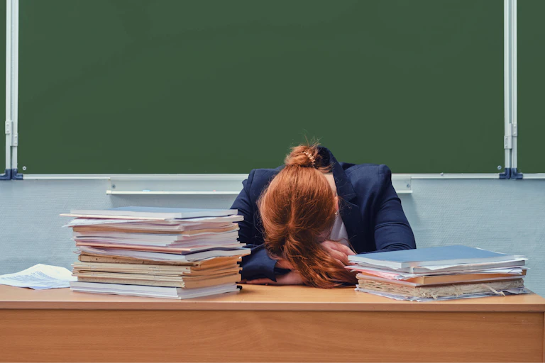 teacher with head on desk
