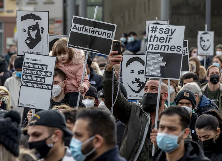A group of protesters holding up sings as they march in the streets.