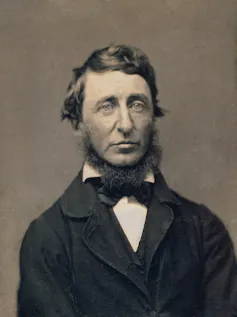 A black and white photo of Henry David Thoreau wearing a suit jacket and bow tie.