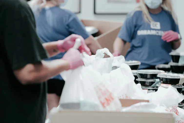 Des personnes tiennent des sacs de poubelle