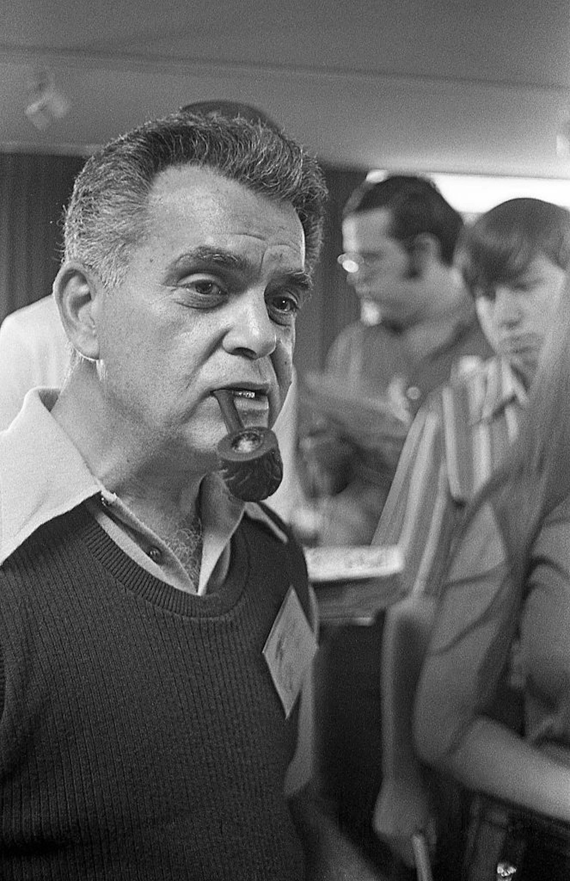 Black-and-white photo of middle-aged white man smoking a pipe.
