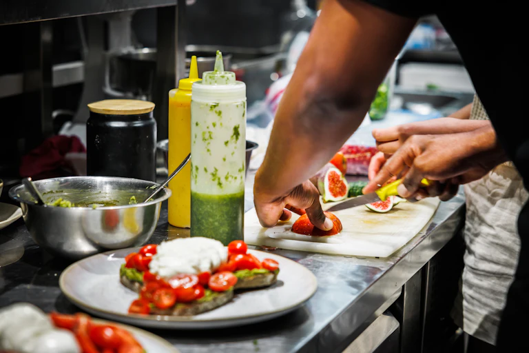 Close up of a chef's hands preparing food in a kitchen