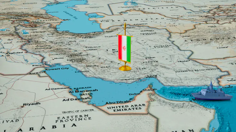 Map of Middle East with Iranian flag and model warship.