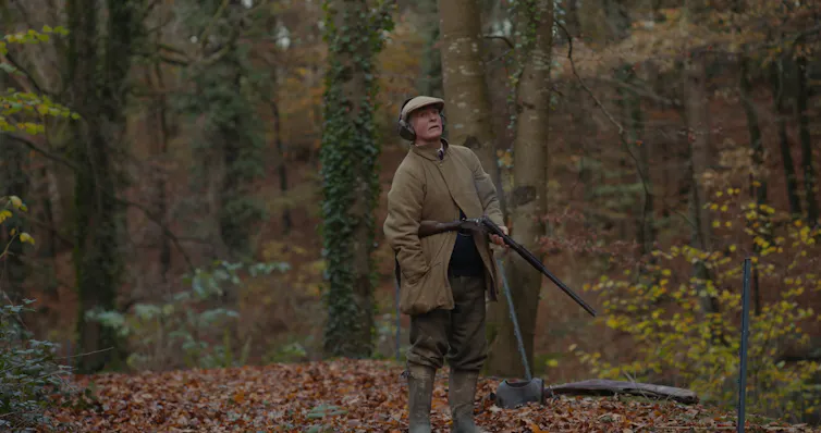 Francis Fulford in the woods with a shotgun