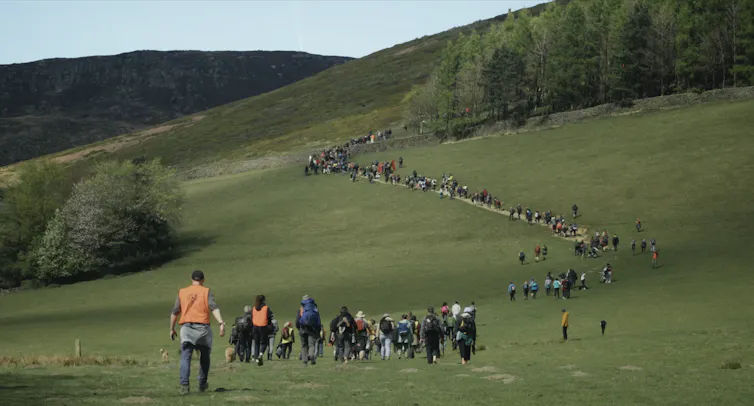 A line of campaigners snaking up a green hill