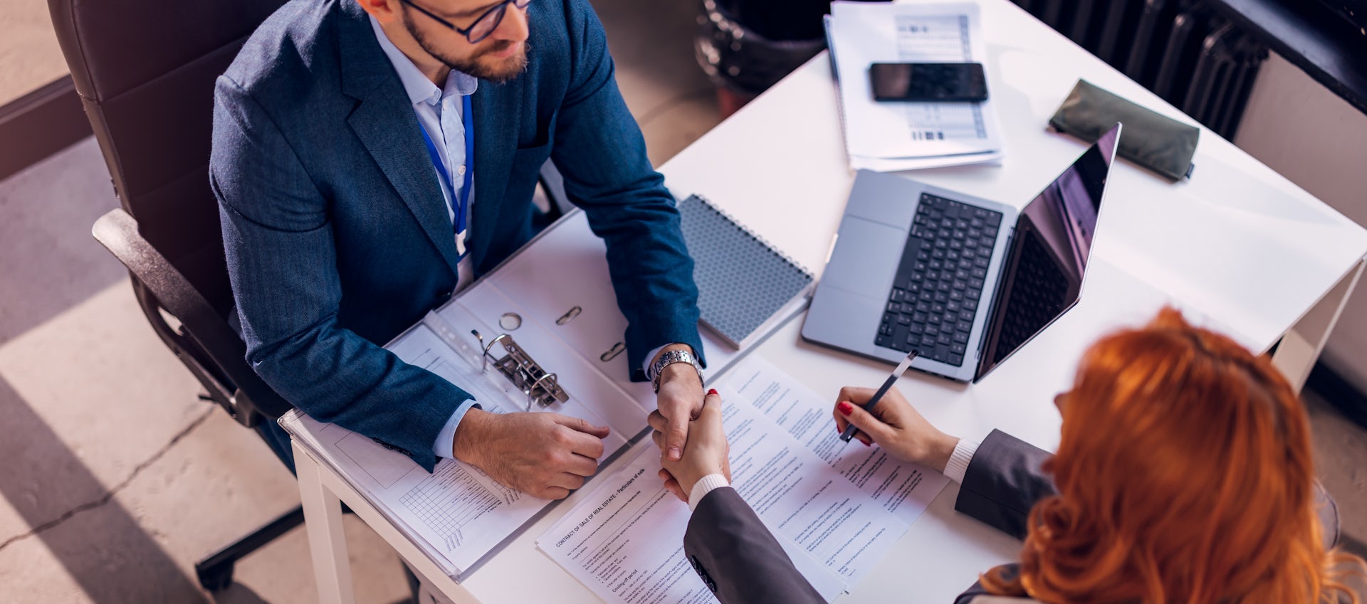 deux personnes (un homme et une femme)  en train de signer un contrat 