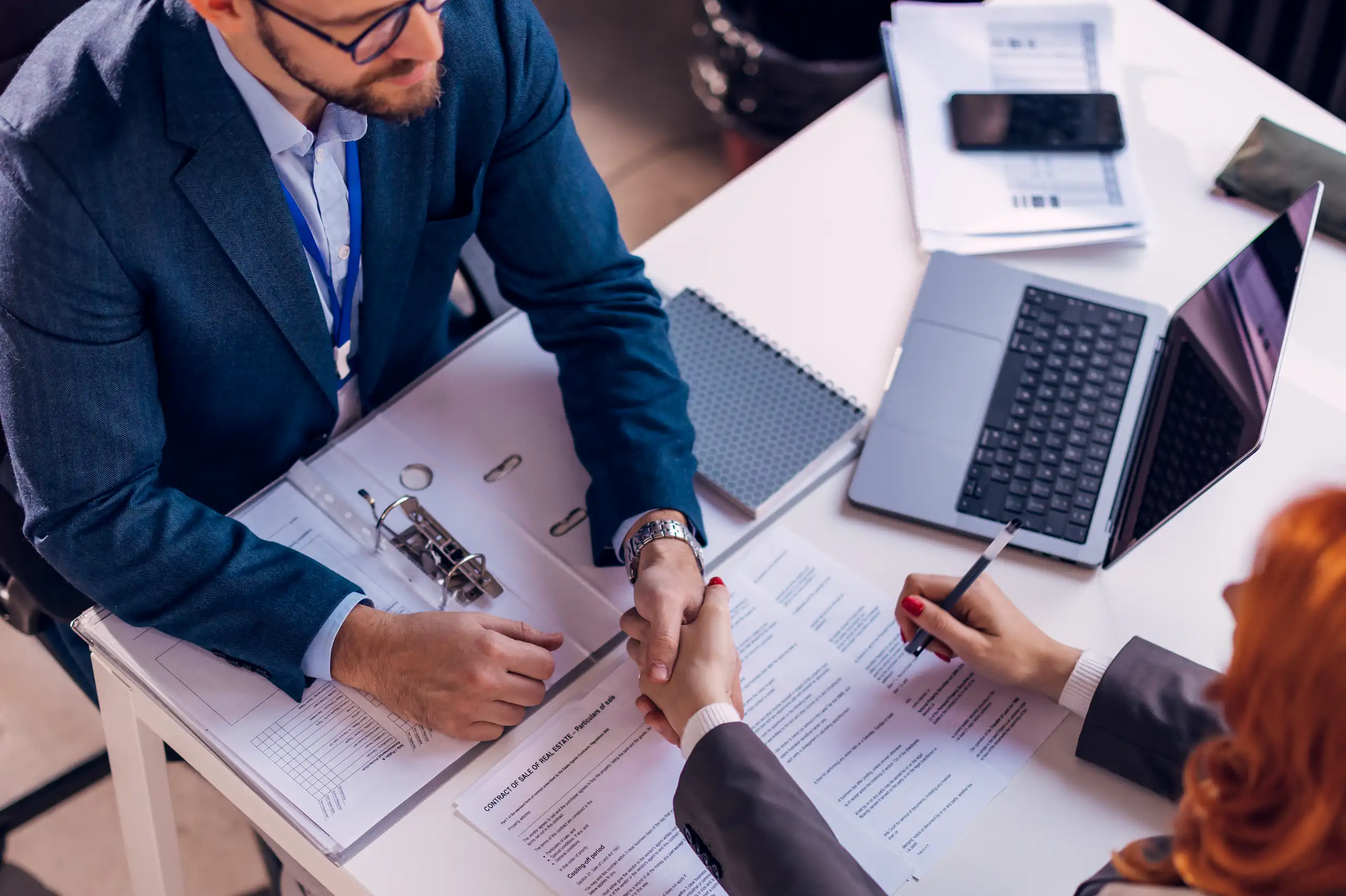 deux personnes (un homme et une femme) en train de signer un contrat