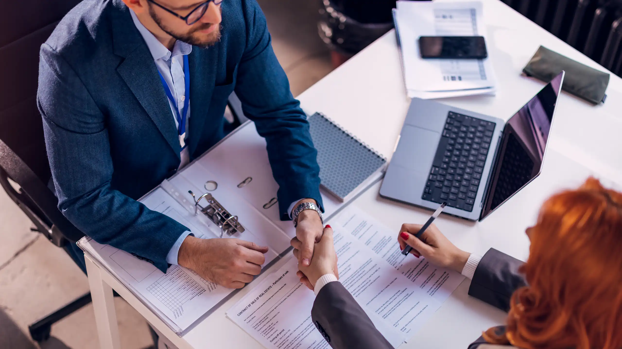 deux personnes (un homme et une femme) en train de signer un contrat