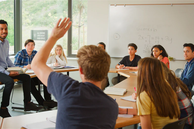 Un alumno levanta la mano en una clase
