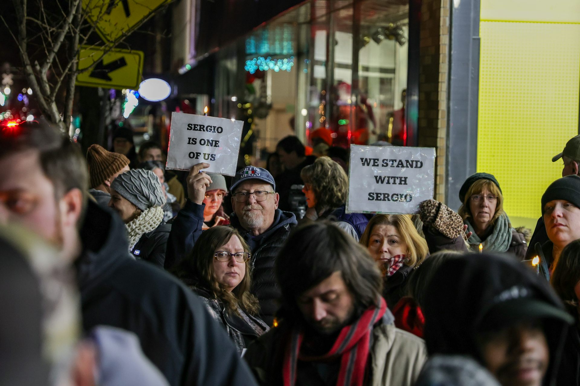 Crowd of people with one holding a sign that reads 'Sergio is one of us' and another holding a sign that reads 'We stand with Sergio'
