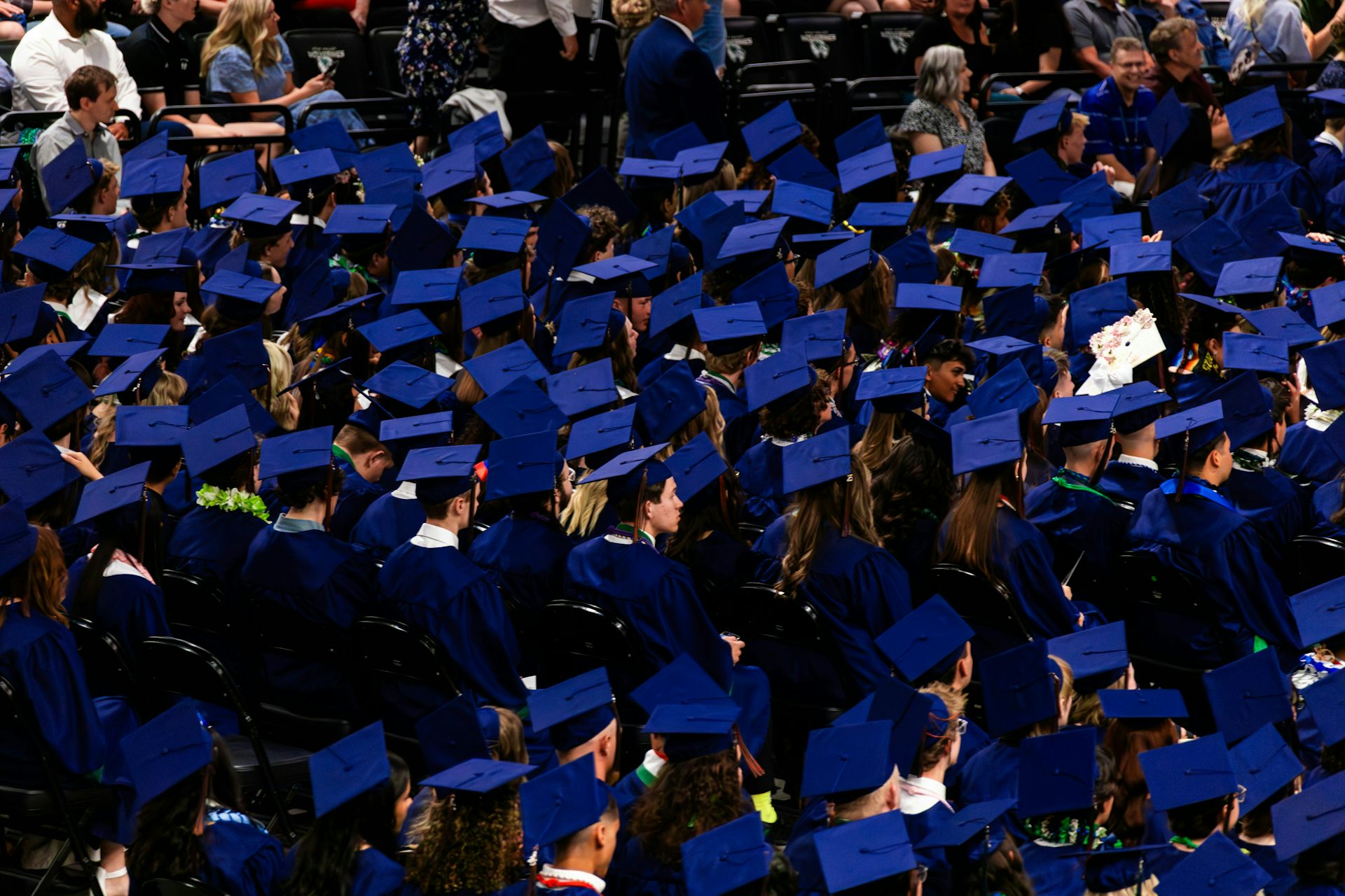Un mar de birretes de graduación mientras los graduados se sientan en filas en la ceremonia.
