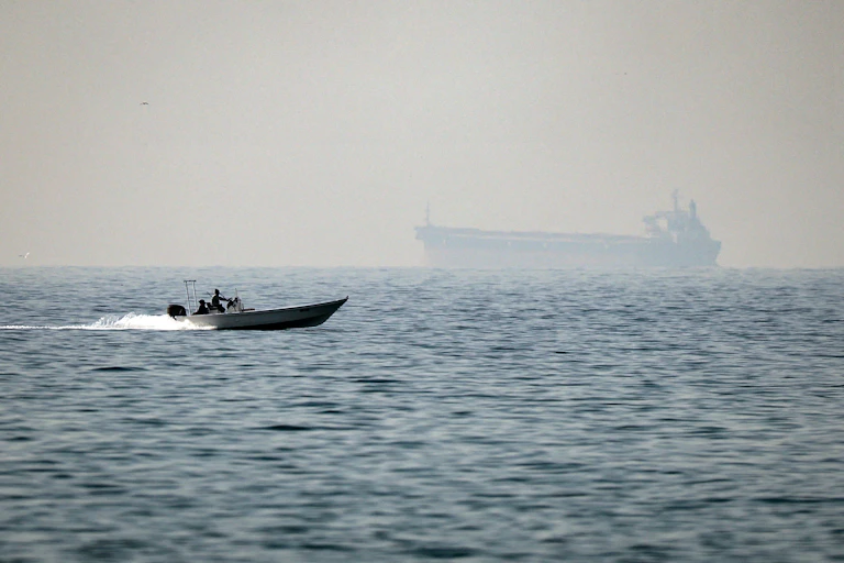 small patrol boat with large tanker in distance