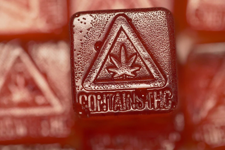 Red cannabis gummy containing with THC content warning