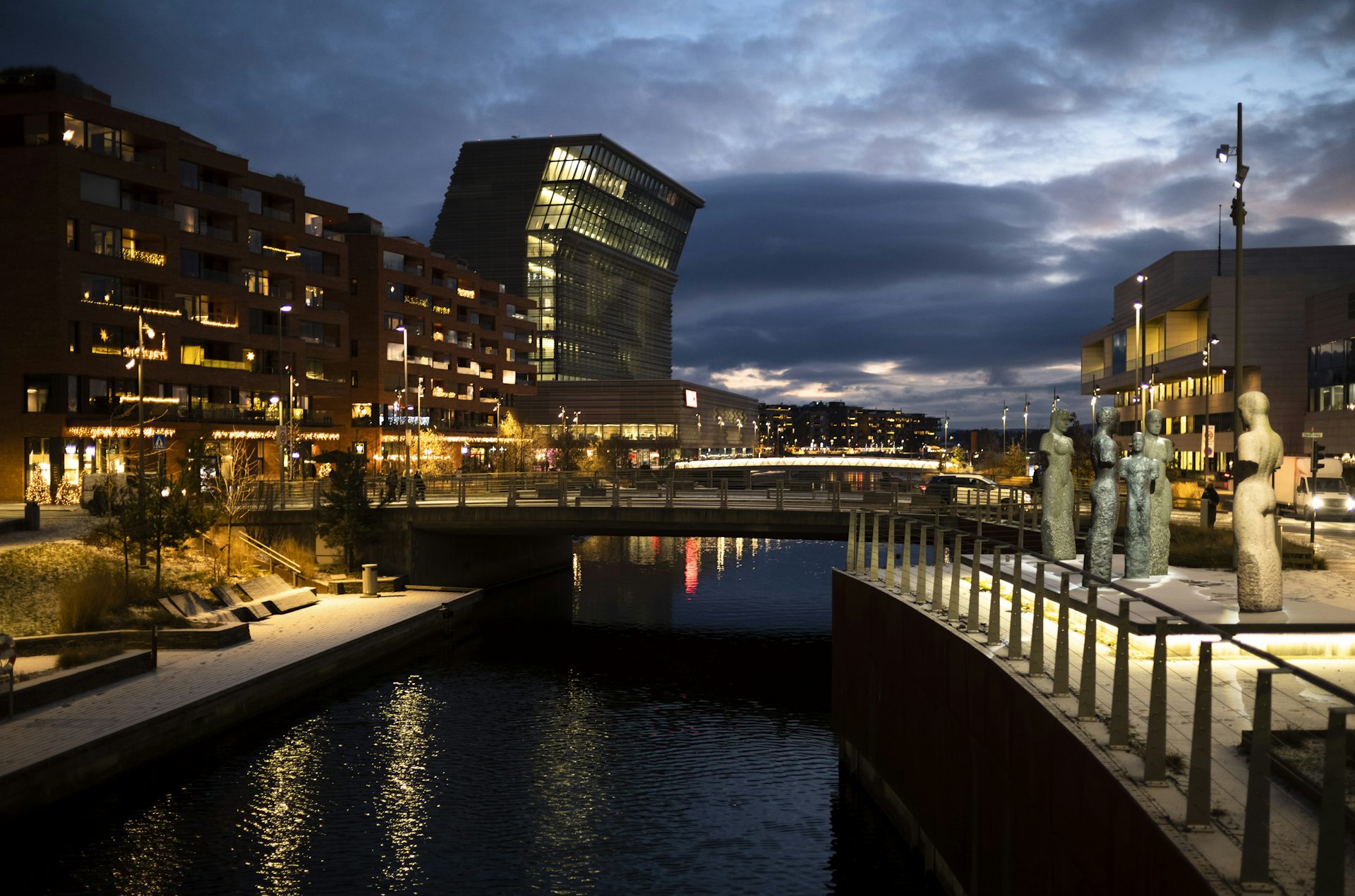 A canal running through a city, which is lit up at night