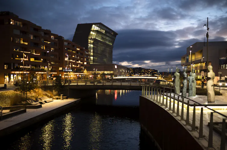 A canal running through a city, which is lit up at night