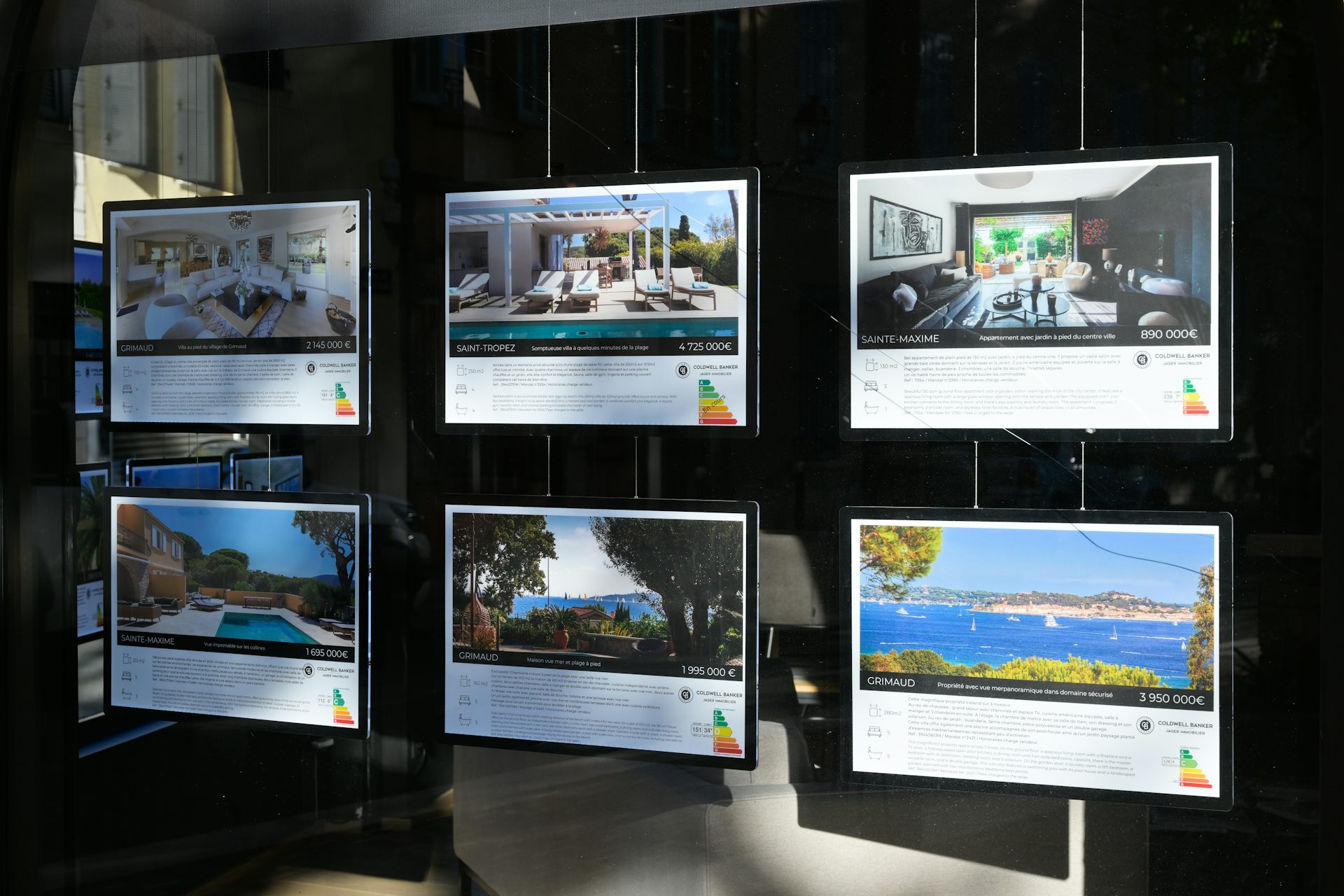 une vitrine d'agence immobilière avec des annonces d'appartements luxueux à Saint Tropez Sainte Maxime Grimaud....