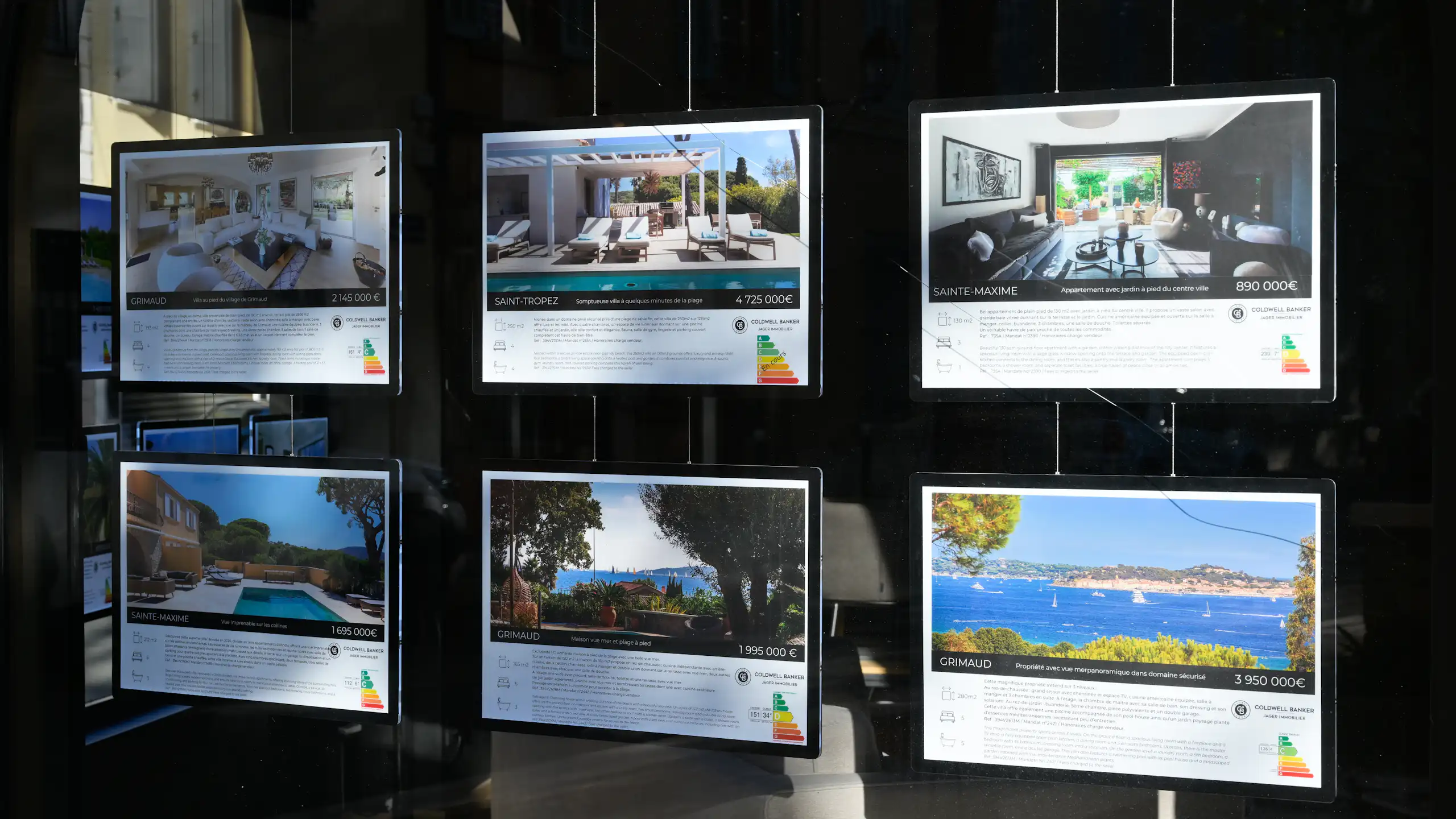 une vitrine d'agence immobilière avec des annonces d'appartements luxueux à Saint Tropez Sainte Maxime Grimaud....