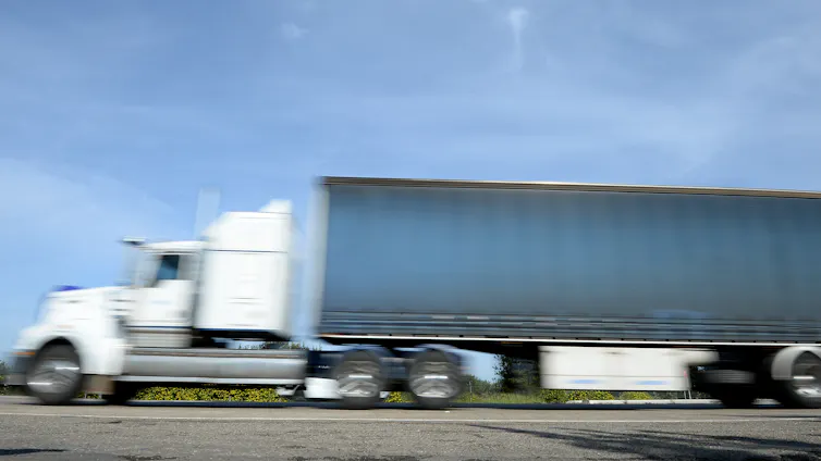 a blurred image of a freight truck driving past