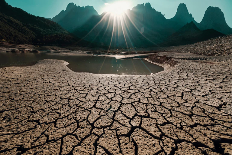 cracked dry ground, hills in background