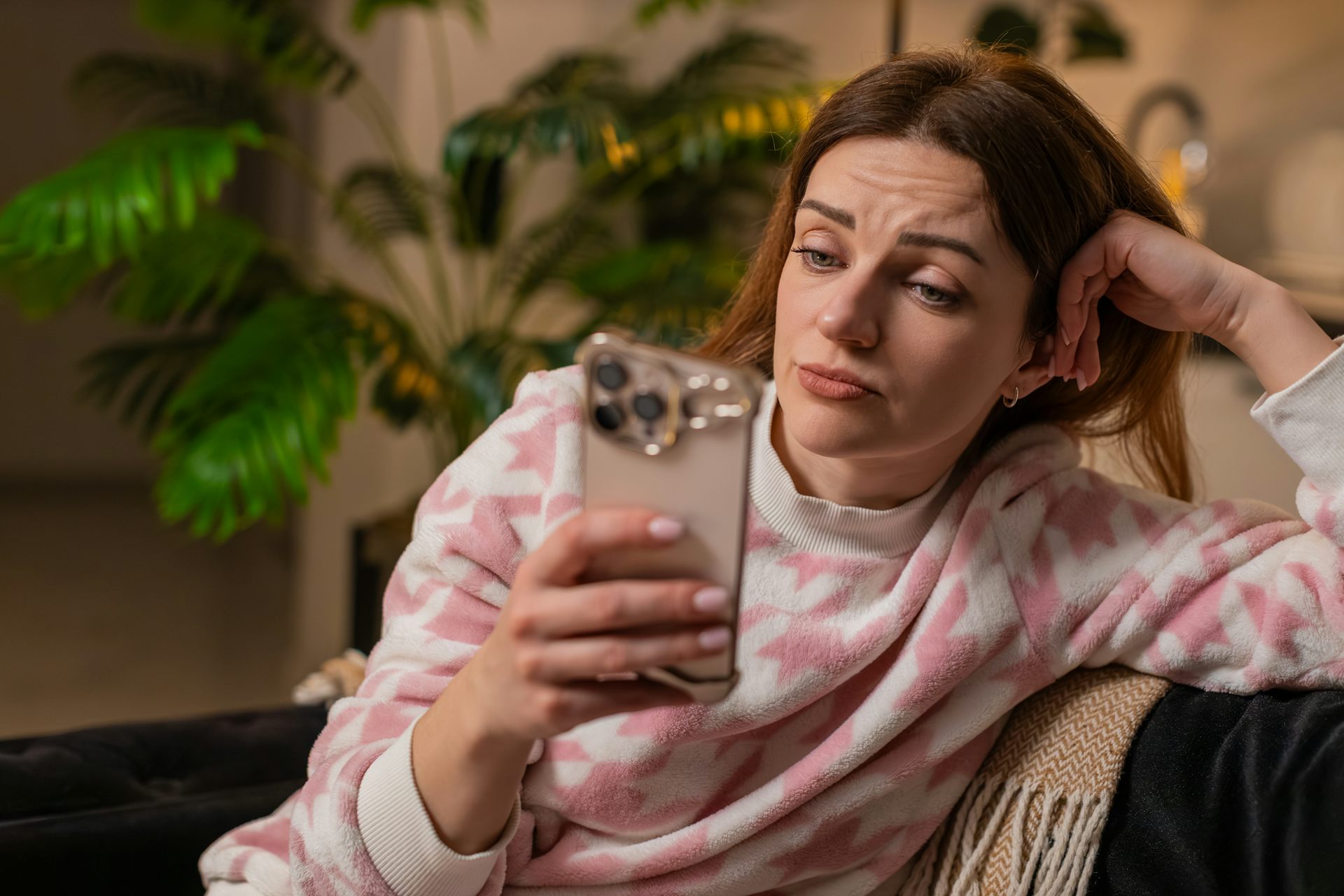 A woman looking sceptically at a mobile phone