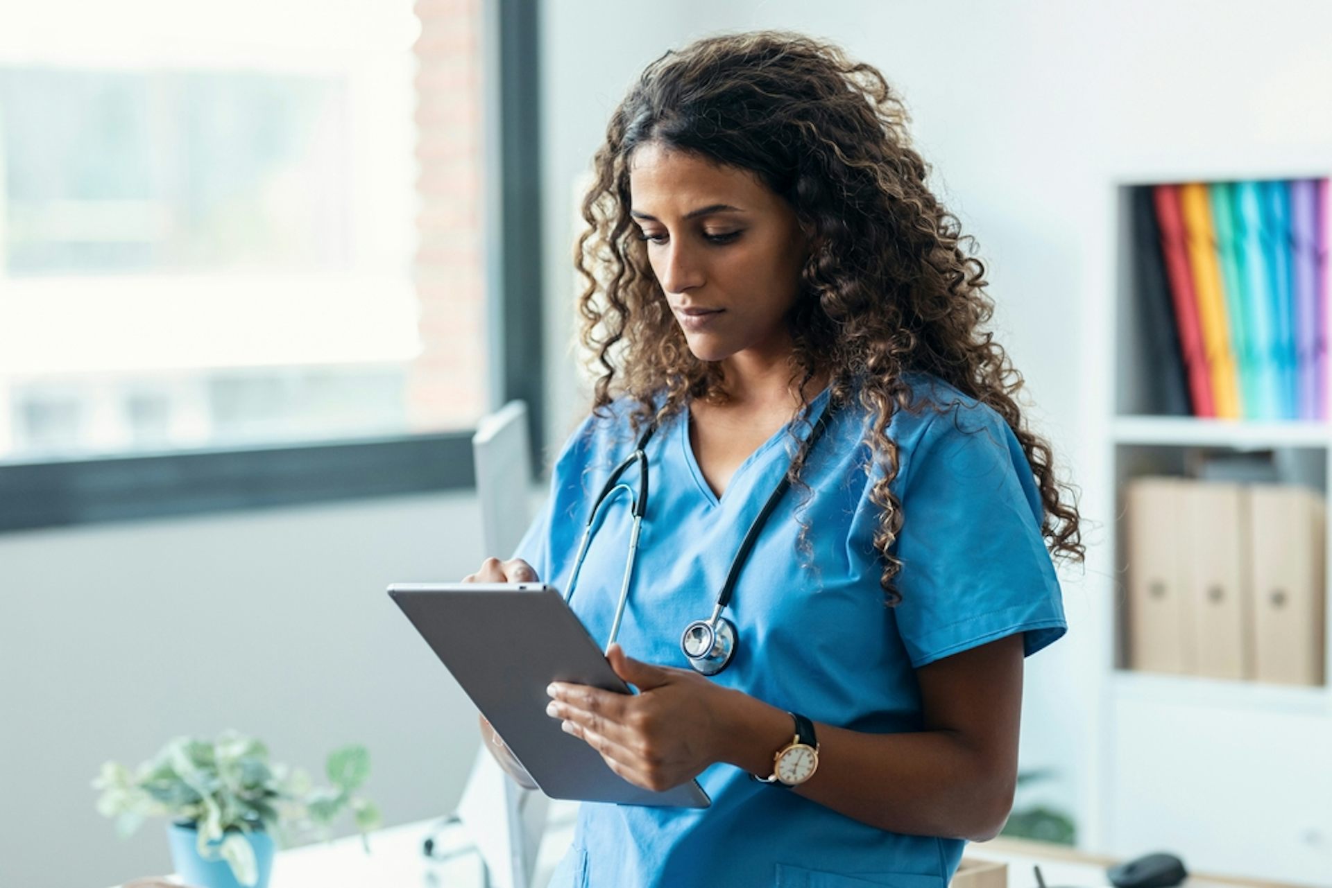 A doctor looking at a tablet computer.
