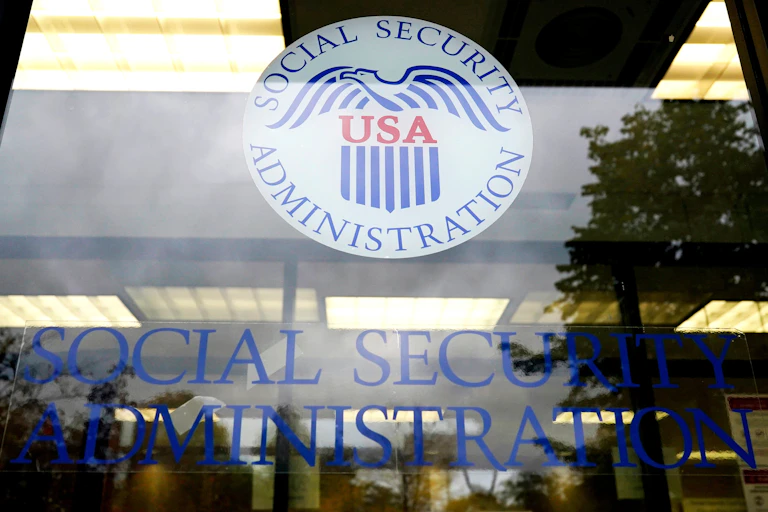 A Social Security office is shown, with items reflected in its large glass wall.