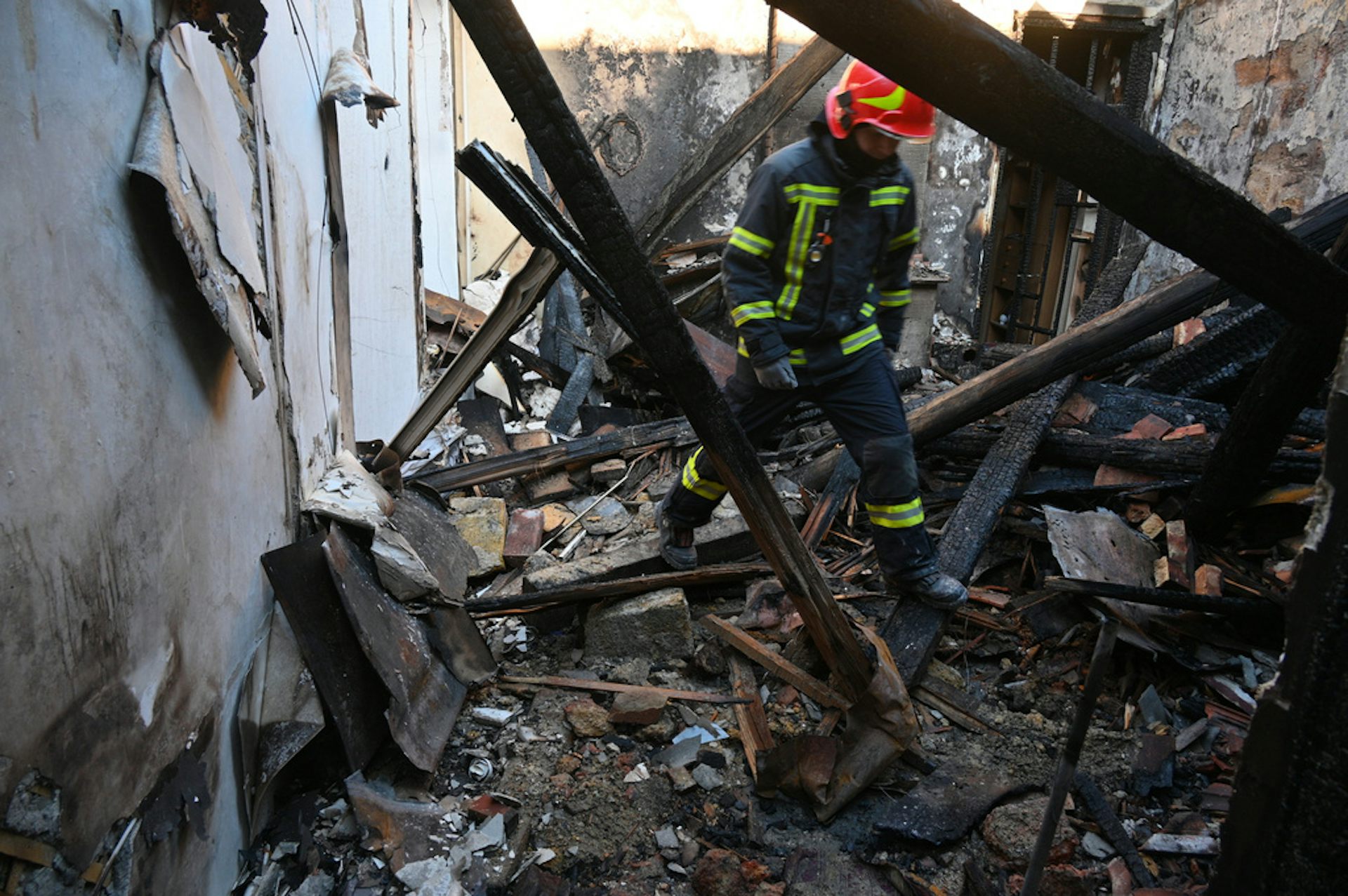 A rescue worker walks among rubble.