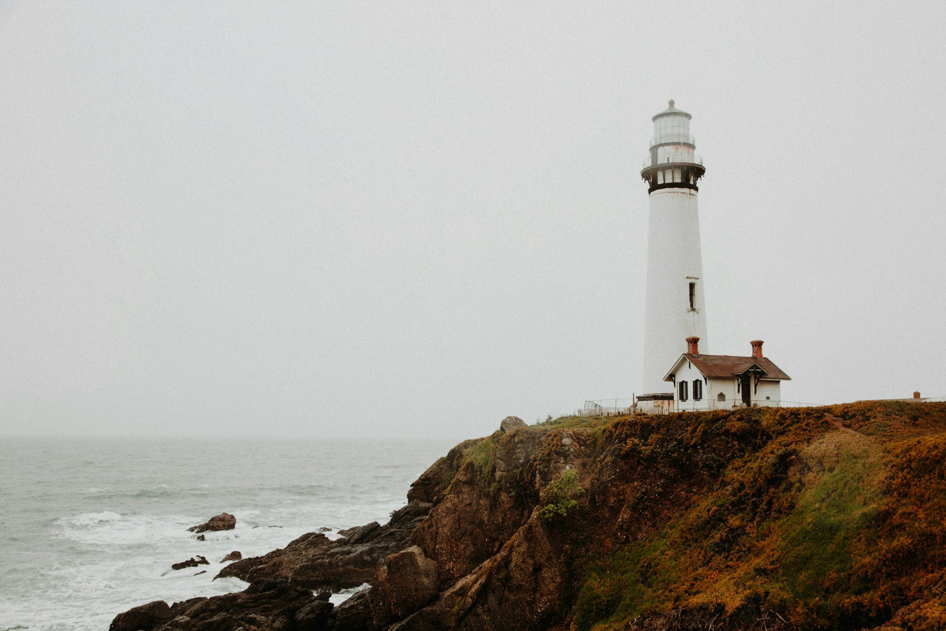 Un phare et une maison face à une étendue d'eau