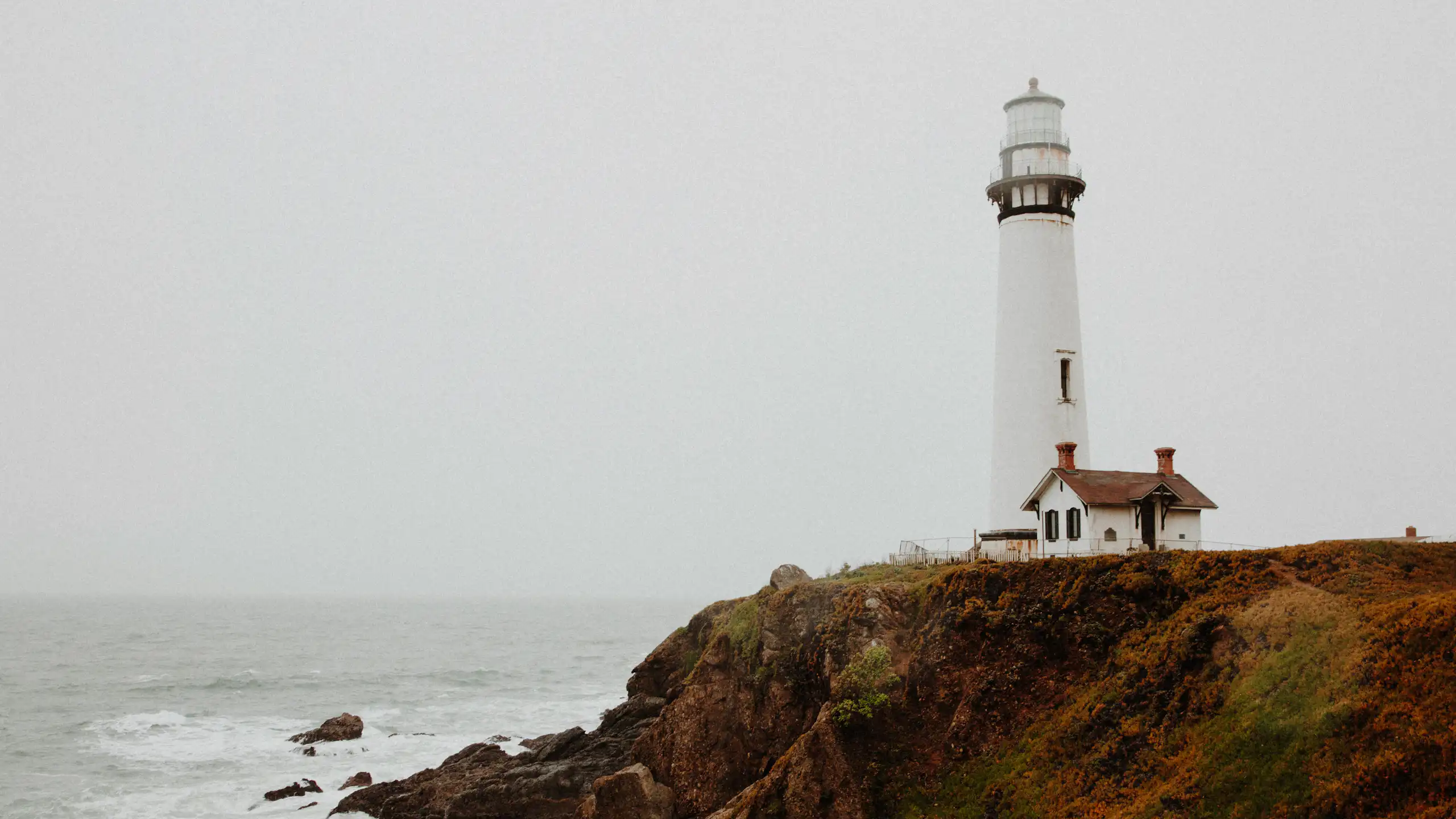 Un phare et une maison face à une étendue d'eau