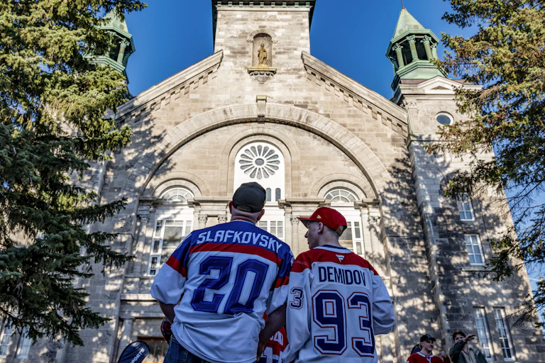 Two people in hockey jerseys approach the front of a church