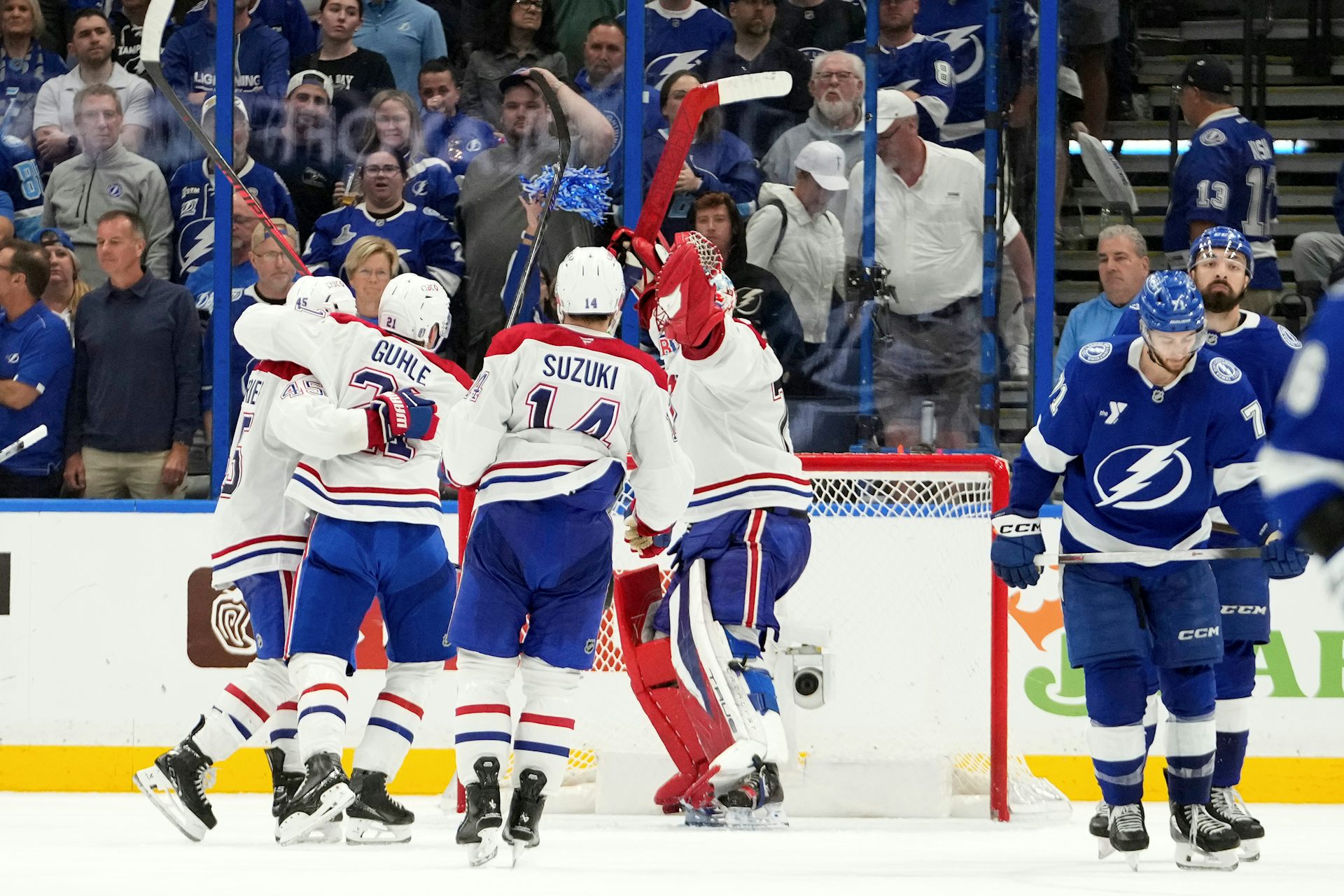 Un grupo de jugadores de hockey se abrazan en el hielo.
