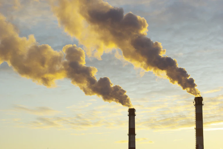 two factory chimneys, smoke from burning coal