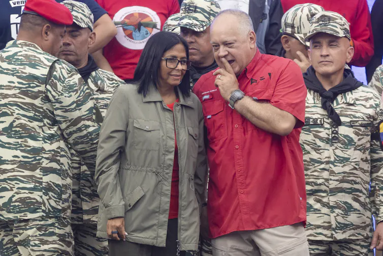 Delcy Rodriguez stands next to Diosdado Cabello at an event.