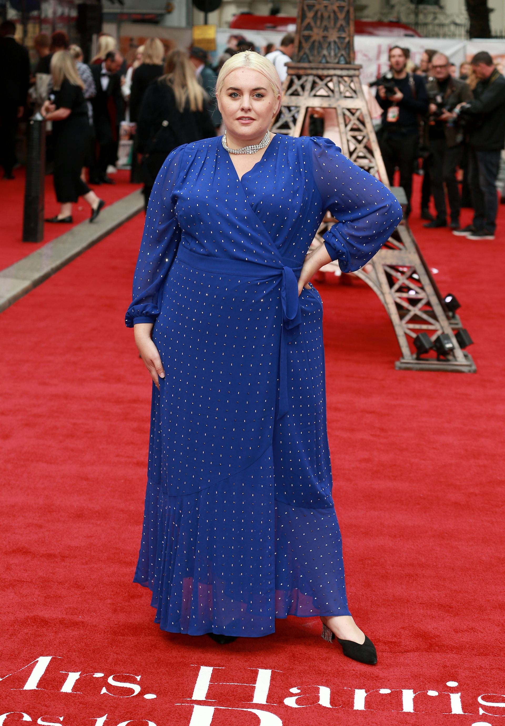 A woman in a blue wrap dress on the red carpet.