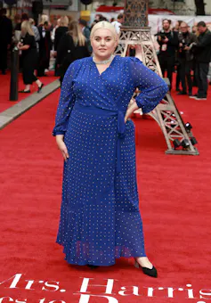 A woman in a blue wrap dress on the red carpet.
