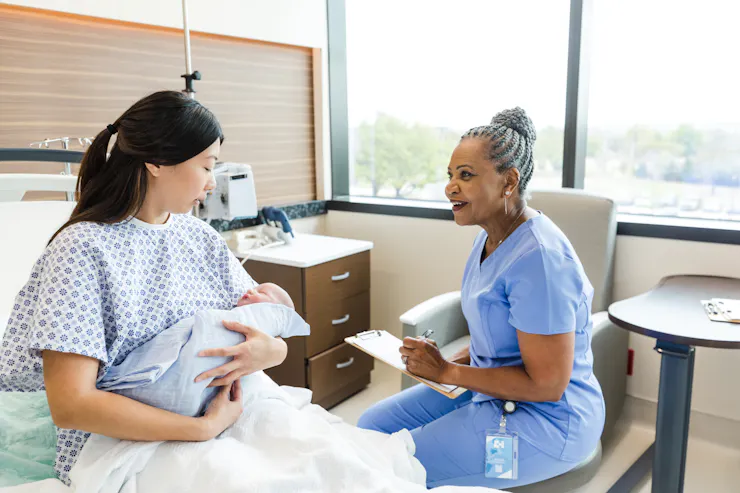 a postpartum mother speaks with a doctor in the hospital