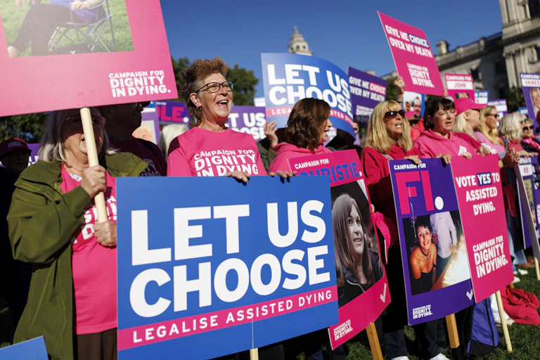 supporters of assisted dying legislation dressed in pink demonstrate at westminster