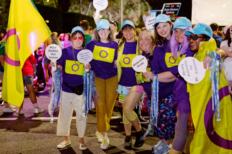 A group of people with innate variations of sex characteristics in purple and yellow, with signs promoting bodily autonomy, at the 2026 Sydney Mardi Gras