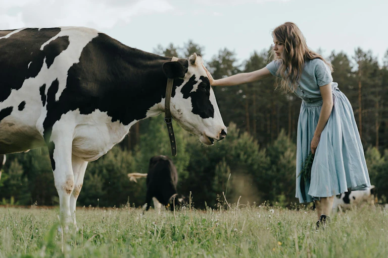 a woman in a dress and a cow