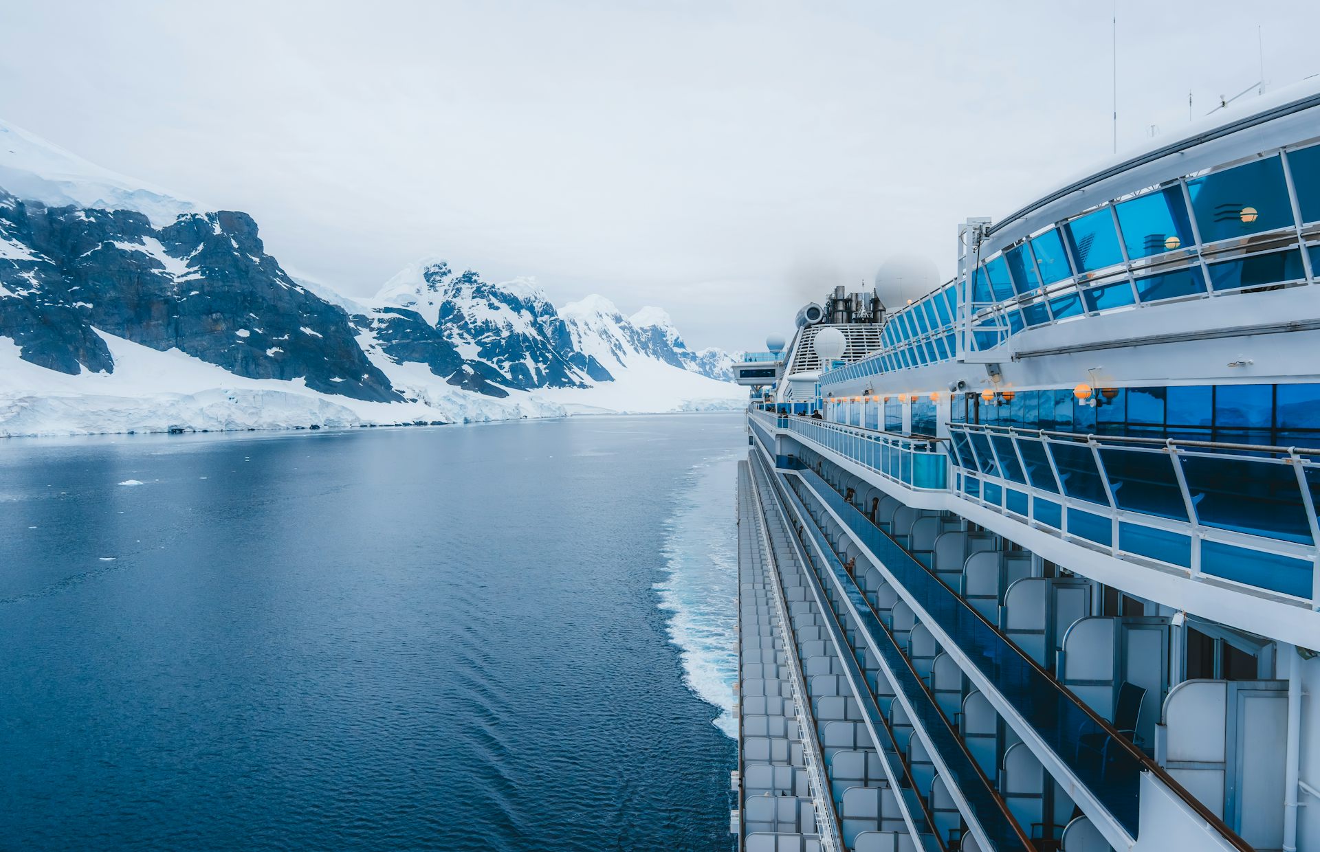 Un creuer bordeja unes muntanyes nevades.