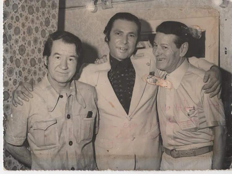 Fotografía de tres hombres sonrientes mirando a cámara.