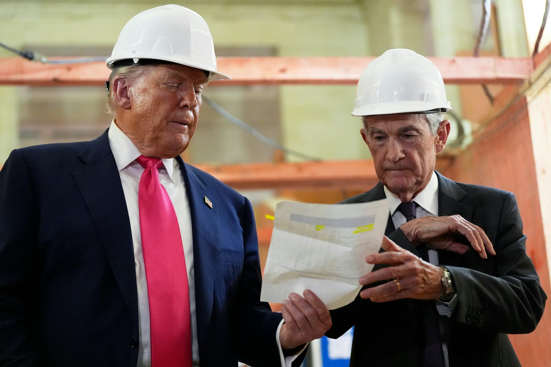 Con cascos, Jerome Powell y Donald Trump revisan un documento sobre costos de construcción durante una visita a la sede de la Reserva Federal el 24 de julio de 2025.
