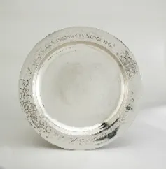 An engraved silver plate is displayed.