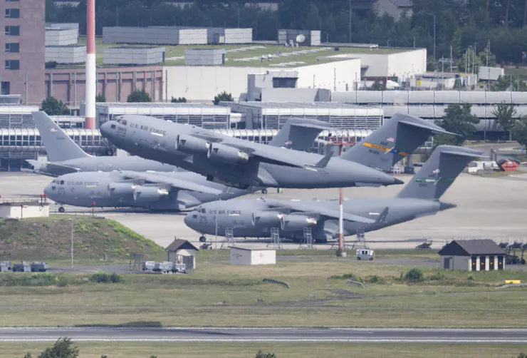 A military transport plane takes off from a runway.