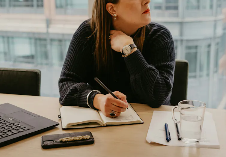 A woman taking notes at a desk