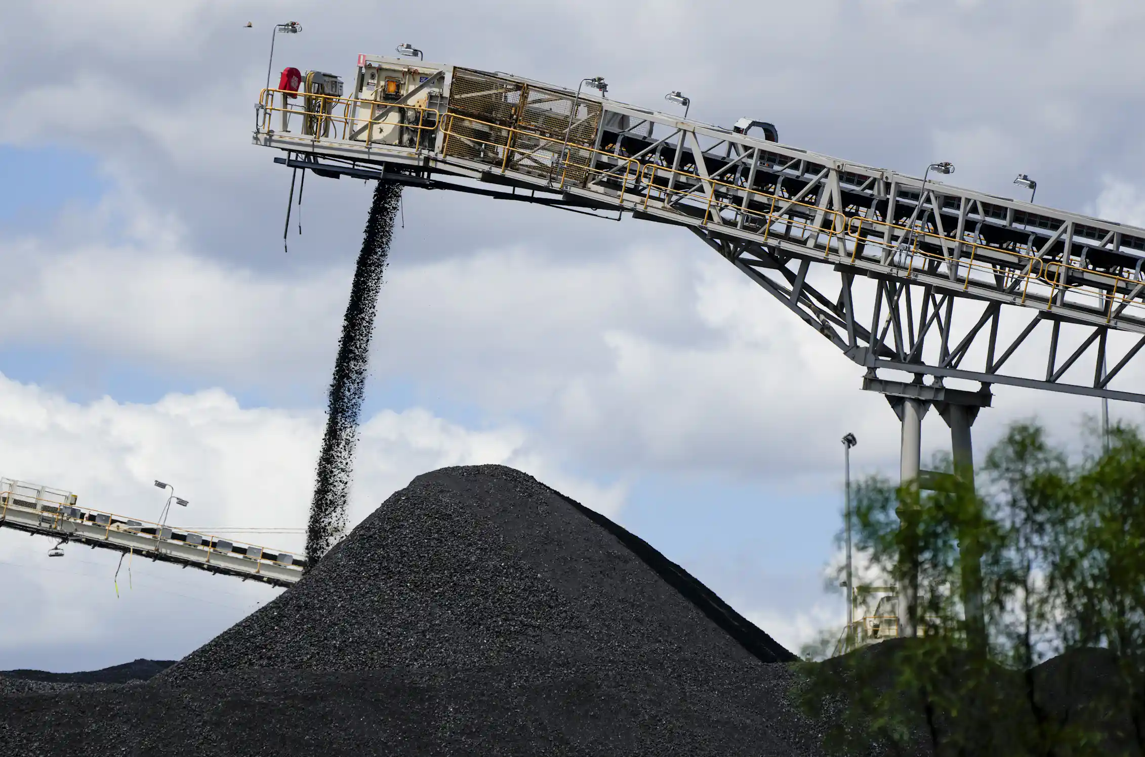 coal being poured by a machine onto a big pile.
