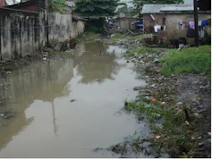 A giant and wide pool of brown water right up to the walls of houses